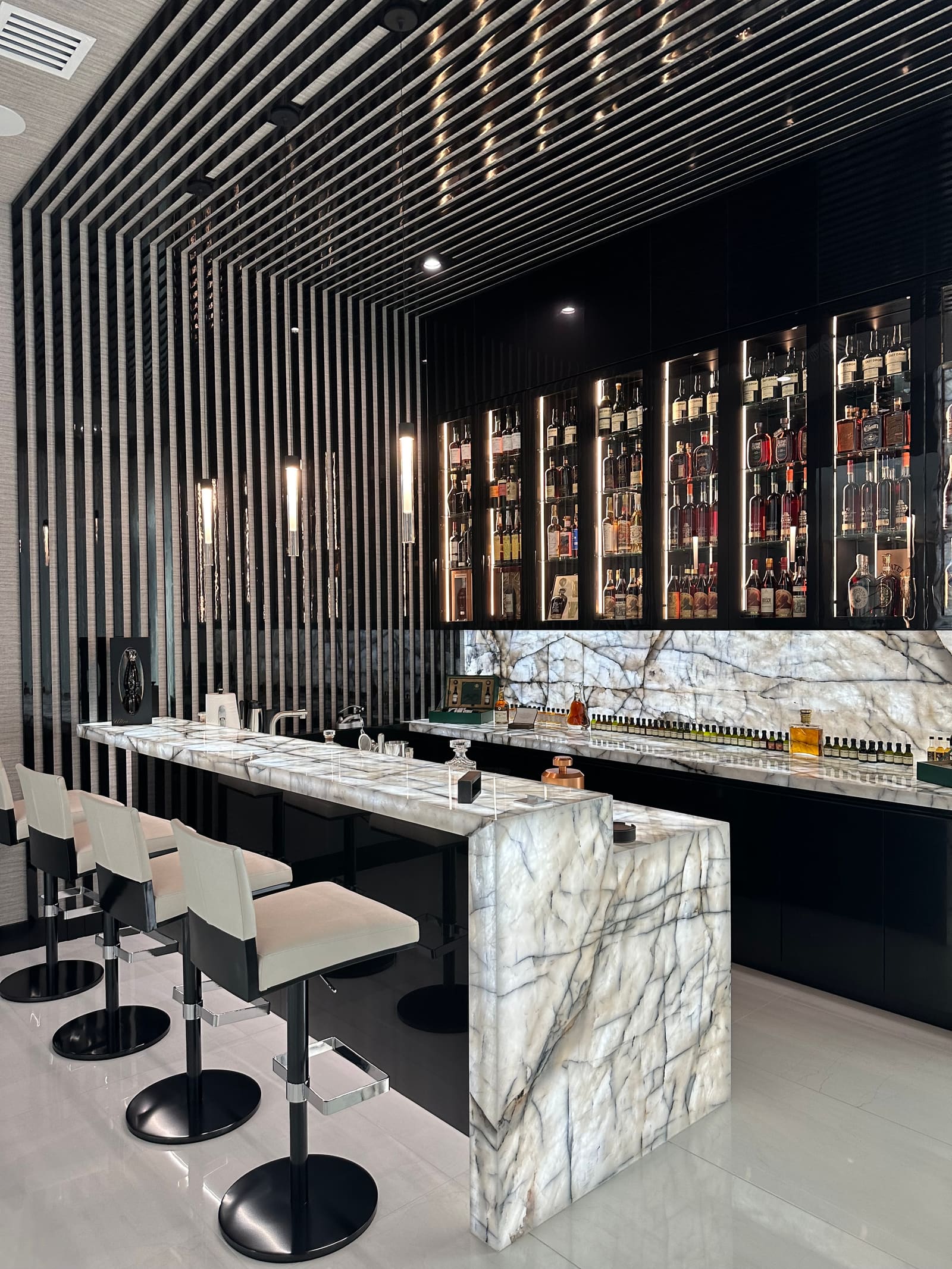 Custom home bar with backlit spirits display and stone counters built by Weston Construction