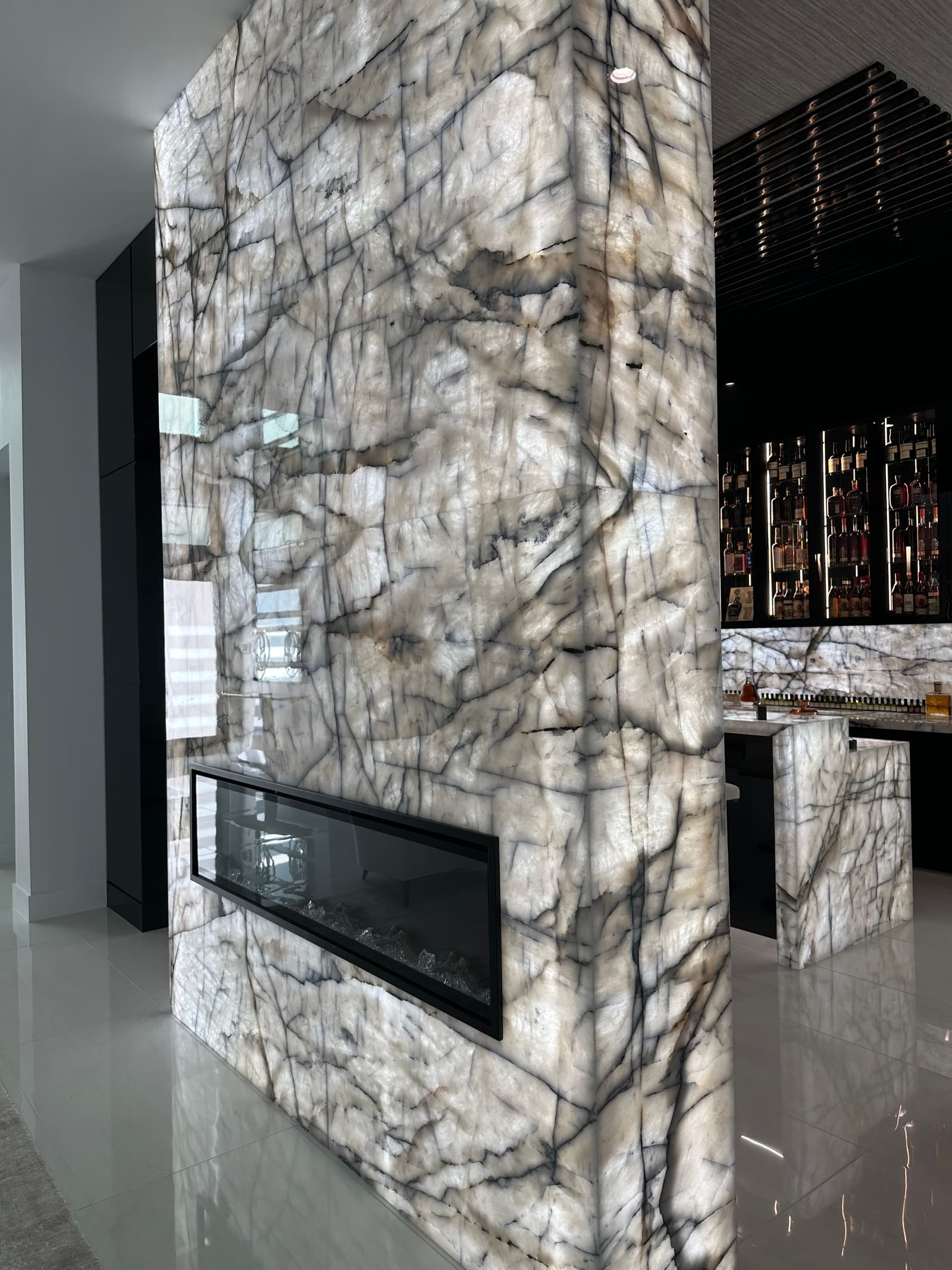 Book-matched stone fireplace feature wall with linear fireplace by Weston Construction